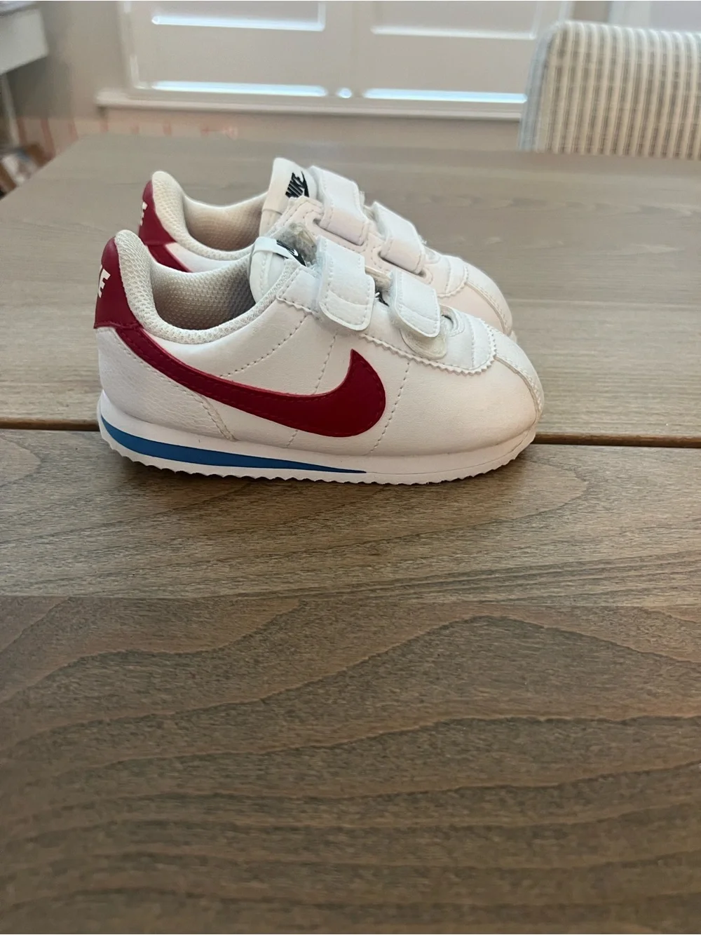 Nike Kids White Sneakers with Red Swoosh and Blue Sole Accent
